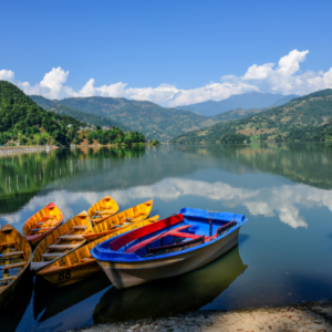 Colourful boats parked along the bank of a river with a scenic Mountain View in Nepal